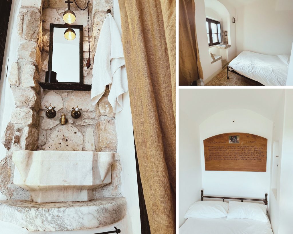 The image is a collage of three photographs showcasing different rooms in a building, possibly an old stone structure. On the left side, there's a large white marble sink with a mirror above it and some towels hanging on the wall. The sink has a rectangular shape with a flat top and no faucets visible. It appears to be an outdoor or indoor water feature made of natural stone, possibly from ancient times. In the middle right photo, there's a small bed with a white duvet and pillows against a plain white wall. There are two windows on either side of the bed, each with dark brown frames. The room has a simple design, with no visible furniture or decorations other than the bed and windows. The bottom right photo shows another small room with a single bed against one wall. This room also features a wooden plaque mounted above the bed, although its text is not legible due to blurriness. The walls of this room are painted white, matching those in the middle-right photo. Overall, these images suggest that they were taken at some point between 2016 and 2021 as part of an effort to document historical sites or buildings for preservation purposes.