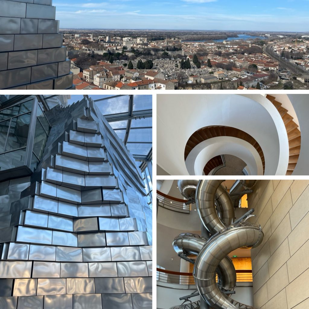 This collage presents a stunning aerial view of a city, accompanied by four photographs that showcase the building's unique architecture. The top photo captures a bird's-eye view of the cityscape, featuring numerous rooftops, buildings, and a body of water in the distance. The surrounding sky is a brilliant blue with wispy clouds. The lower-left photograph reveals the interior of the building, showcasing a striking staircase composed of silver metal tiles arranged in a wave-like pattern. The adjacent photo displays an expansive spiral staircase with white walls, while the bottom-right image presents a massive sculpture featuring four interconnected rings made from shiny steel or chrome, suspended against a beige wall. The overall atmosphere exudes modernity and sleekness, suggesting that this building is either a contemporary art museum or gallery space.